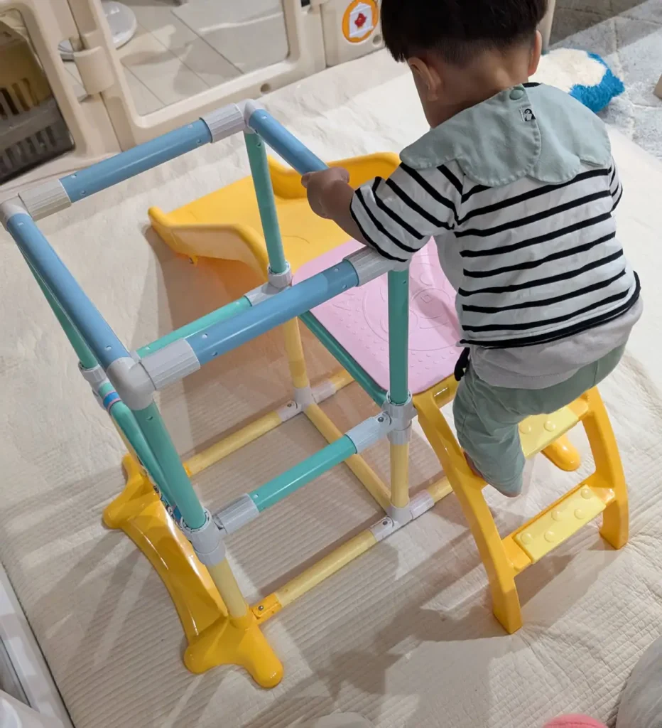 室内ジャングルジムの階段を登る1歳児の様子
